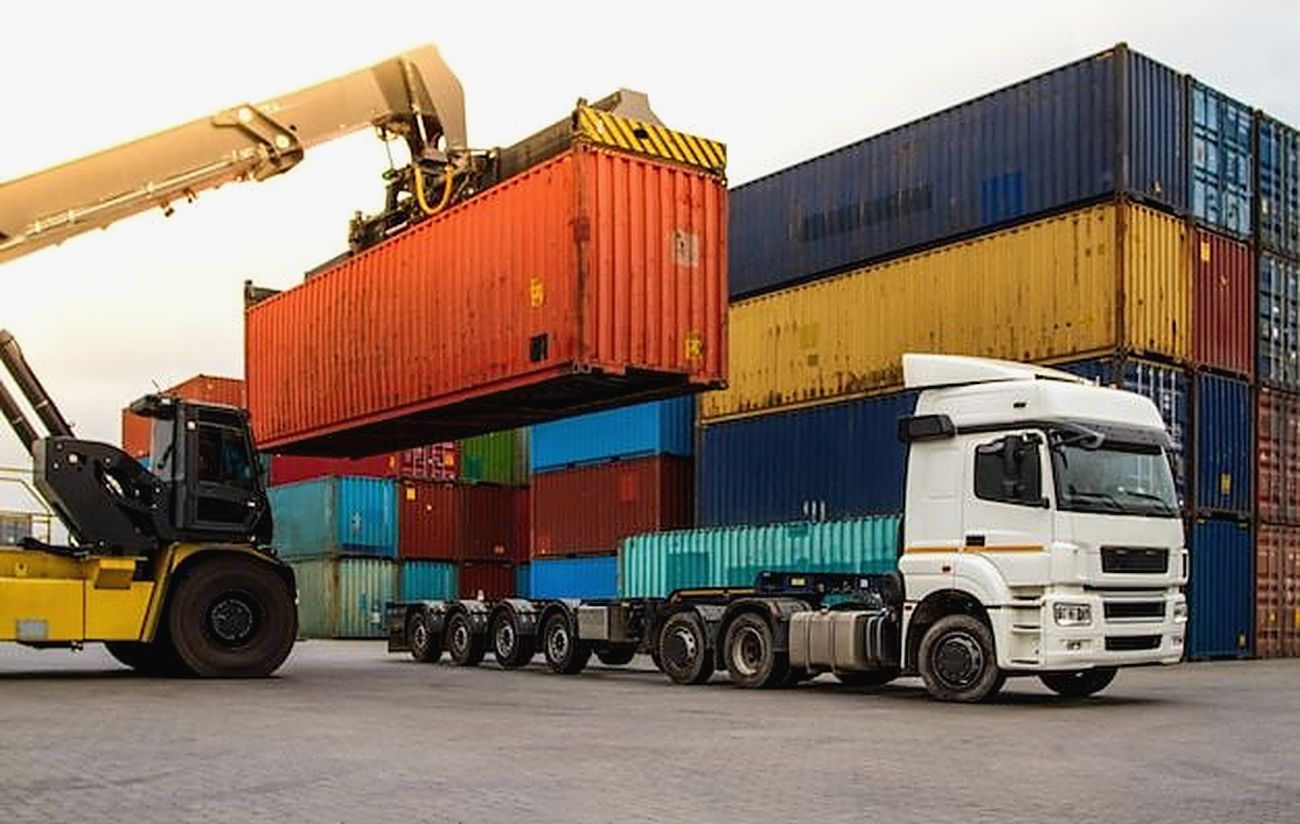 Un conteneur soulevé par un chariot avant son chargement sur un camion